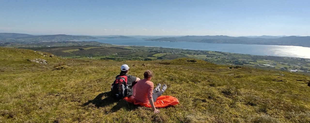 two people sitting down and overlooking lake